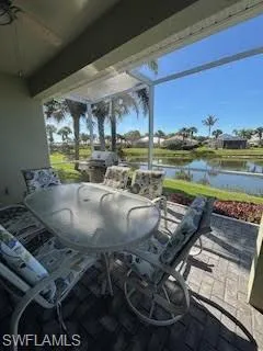 View of patio / terrace with a water view, glass enclosure, and outdoor dining space