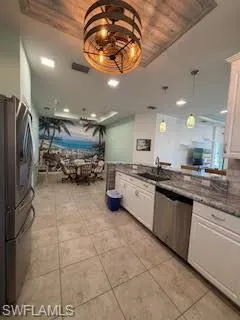 Kitchen featuring white cabinets, appliances with stainless steel finishes, and wooden ceiling