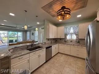 Kitchen featuring white cabinets, stainless steel appliances, a healthy amount of sunlight, and a sink