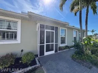 View of side of home with stucco siding and a sunroom
