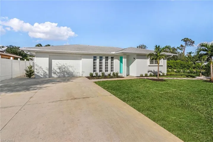 Single story home featuring a garage and a front lawn