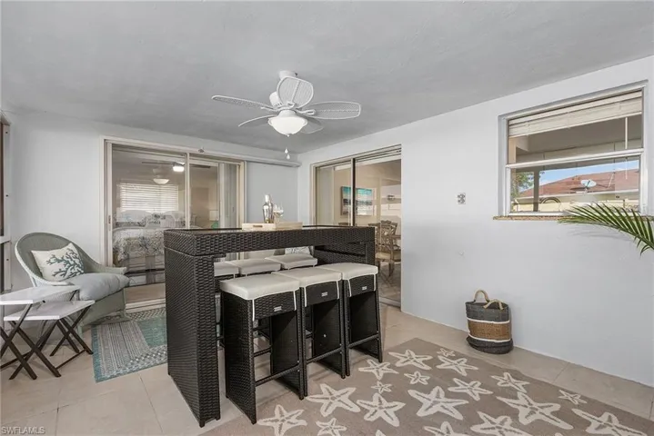 Tiled dining space featuring ceiling fan and a healthy amount of sunlight