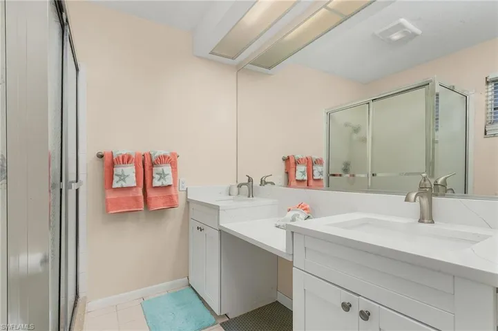 Bathroom with tile patterned floors, an enclosed shower, and vanity