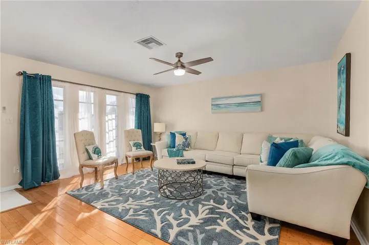 Living room with light wood-type flooring and ceiling fan