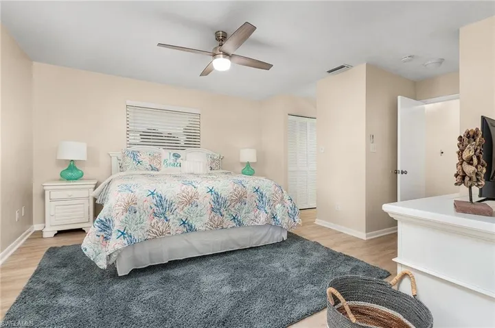 Bedroom with light wood-type flooring, ceiling fan, and a closet