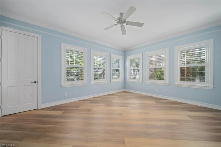 Spare room with ornamental molding, ceiling fan, and light hardwood / wood-style floors