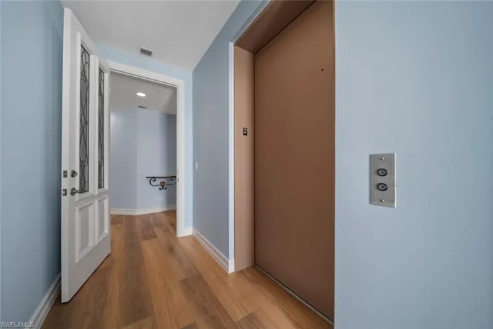 Hall featuring elevator and light hardwood / wood-style floors
