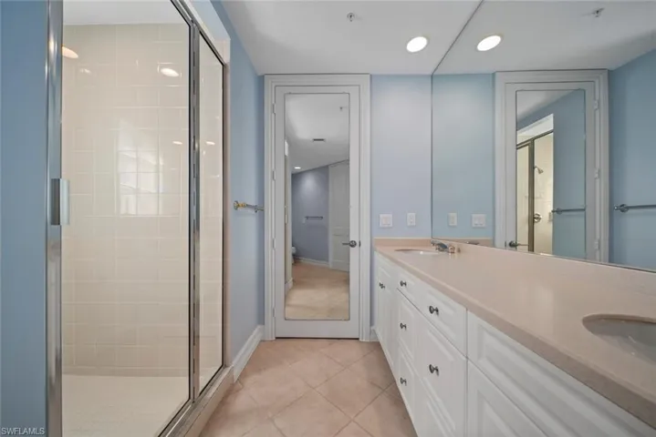 Bathroom featuring vanity, tile patterned floors, and a shower with shower door