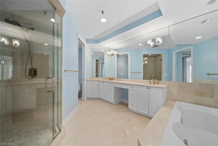 Full bathroom featuring an inviting chandelier, vanity, toilet, and plus walk in shower
