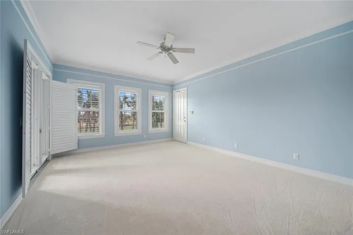 Carpeted empty room with ornamental molding and ceiling fan