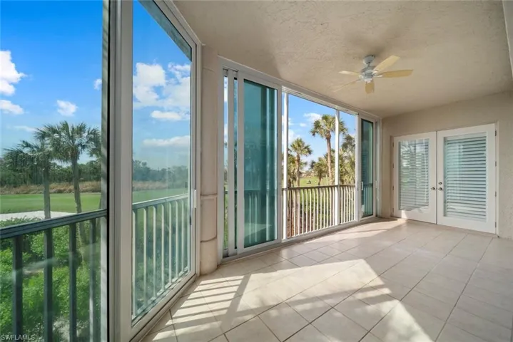 Unfurnished sunroom featuring ceiling fan