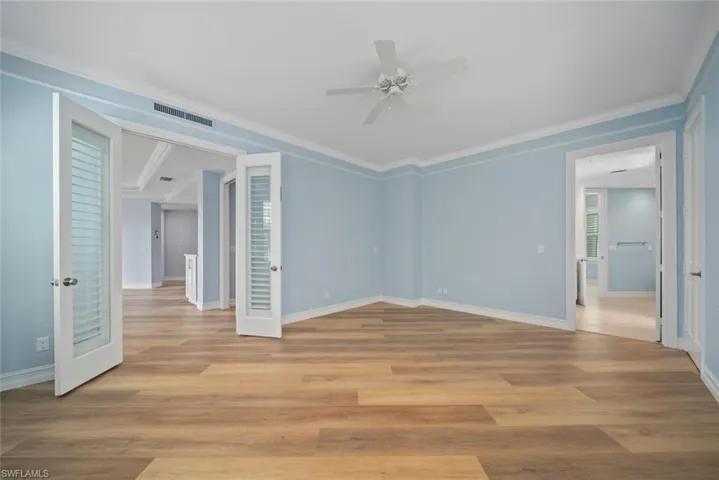 Spare room featuring ceiling fan, light hardwood / wood-style flooring, french doors, and ornamental molding