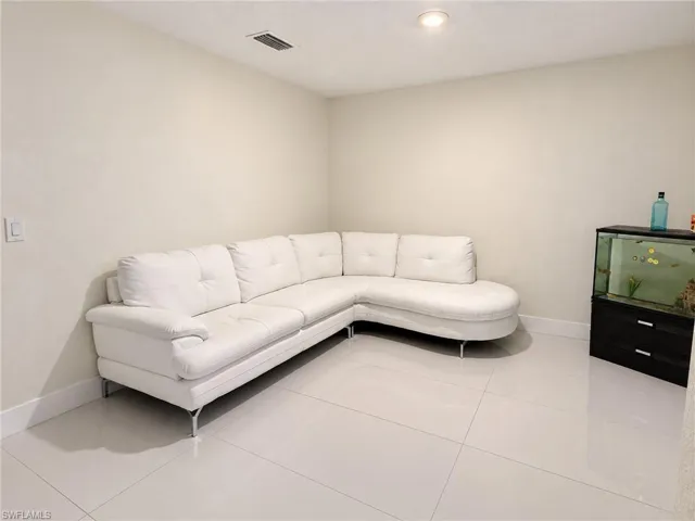 Neutral interior space featuring polished tile flooring, smooth wall finish, and recessed ceiling lighting