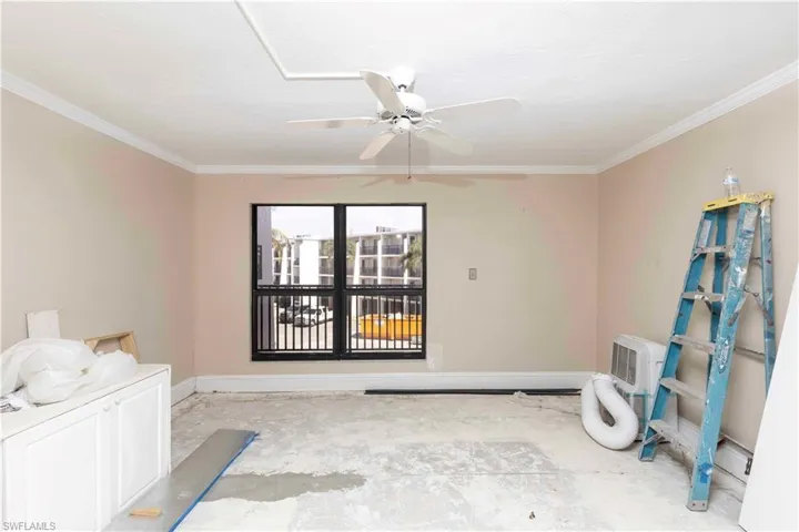 Empty room featuring ceiling fan and crown molding
