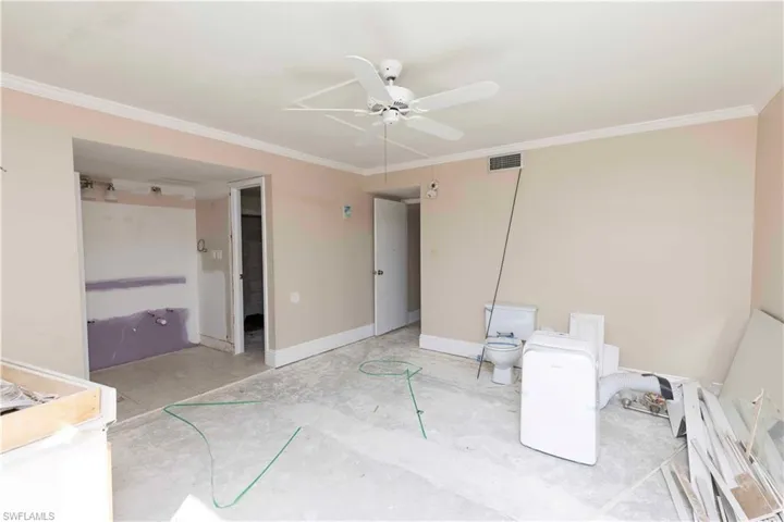 Unfurnished bedroom with crown molding, ensuite bath, and ceiling fan