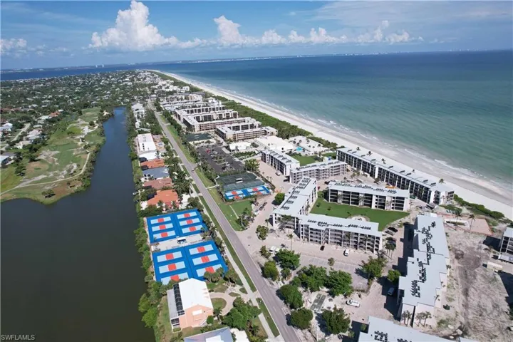 Aerial view featuring a water view and a beach view