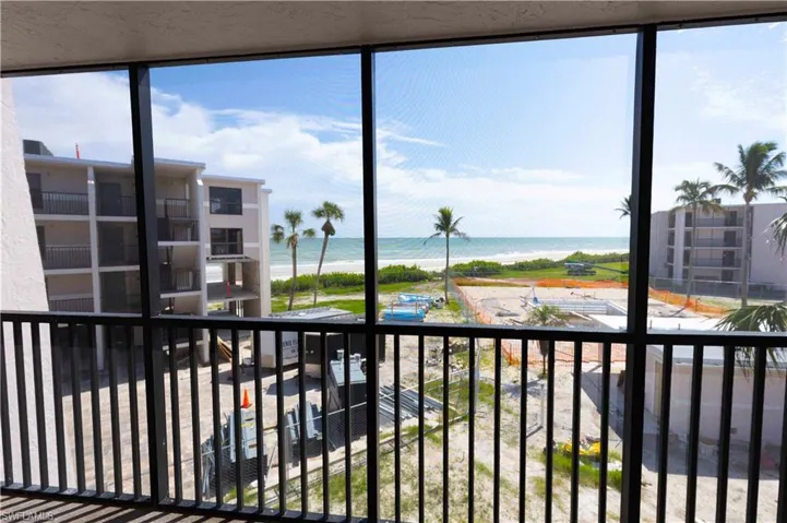 Balcony featuring a water view and a beach view