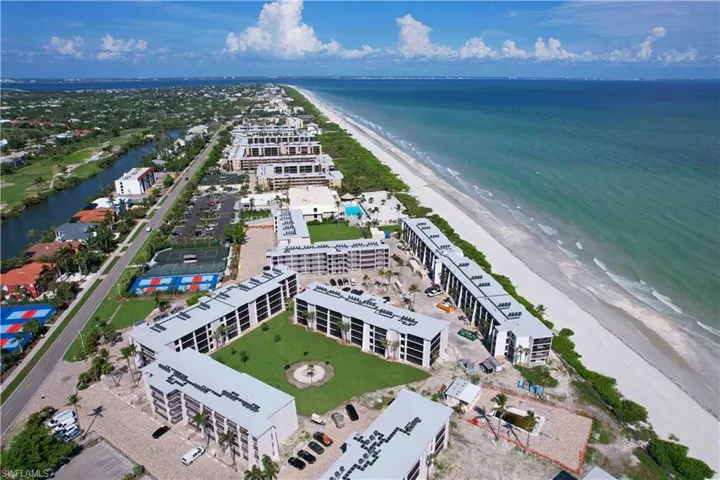 Birds eye view of property with a beach view and a water view