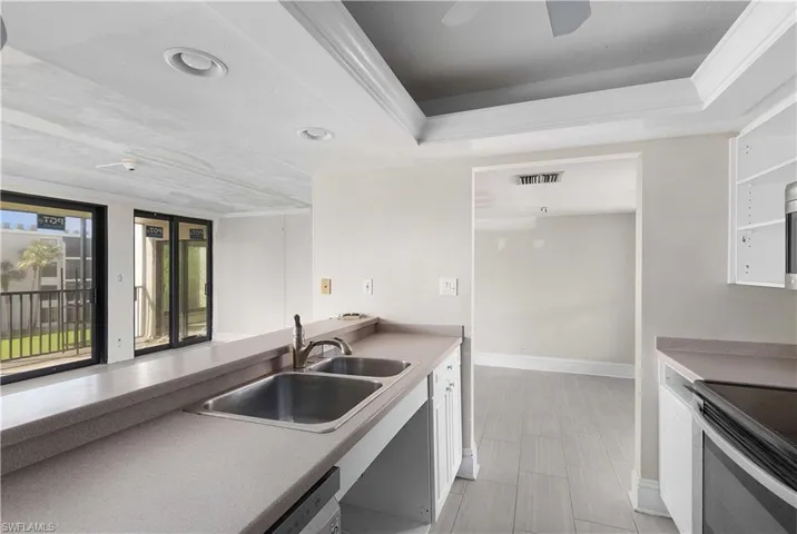 Kitchen featuring white cabinetry, ceiling fan, dishwasher, and sink