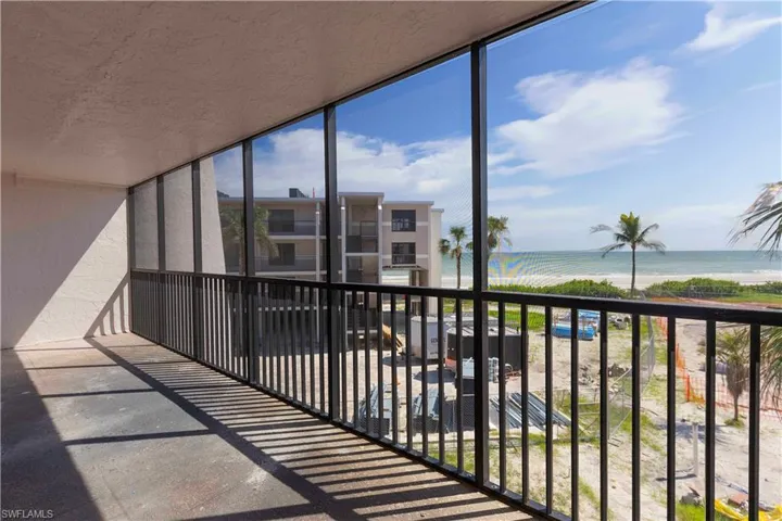 Balcony featuring a water view and a beach view