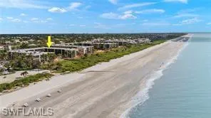 Birds eye view of property with a view of the beach and a water view