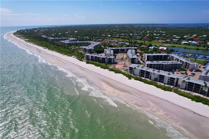 Birds eye view of property featuring a water view and a beach view