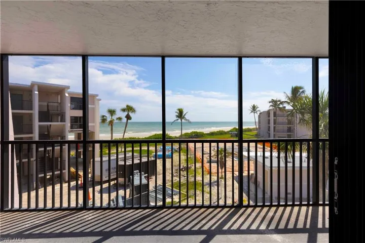 Sunroom / solarium with a water view and a view of the beach