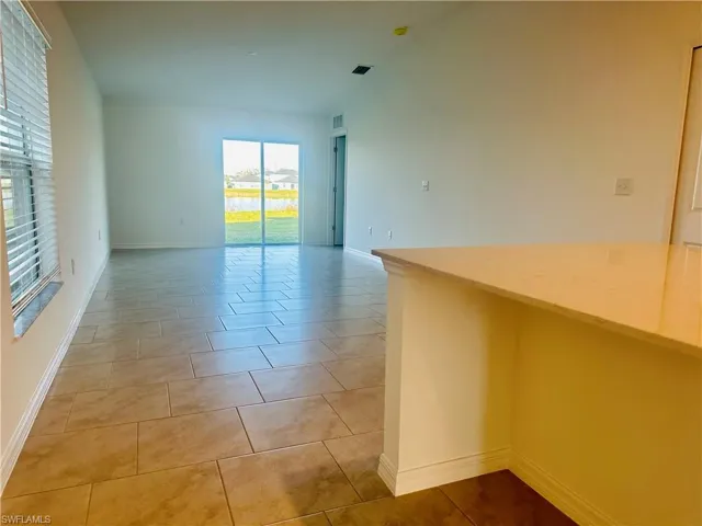 Unfurnished room with light tile patterned floors and baseboards