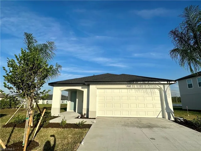 View of front of house with concrete driveway, stucco siding, a garage, and roof with shingles