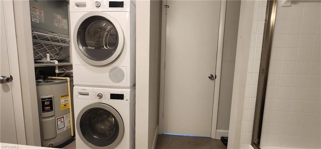 Laundry room with stacked washer / dryer and water heater