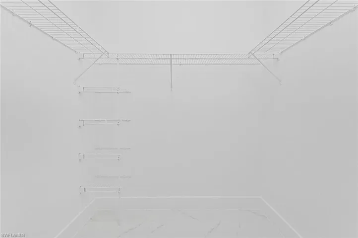 Spacious closet featuring marble look tile flooring