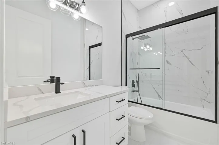 Bathroom featuring enclosed tub / shower combo and vanity
