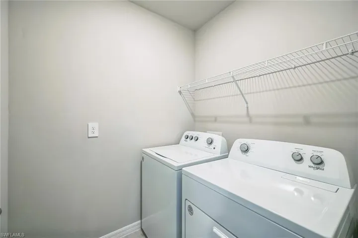 Laundry room featuring washing machine and clothes dryer and baseboards