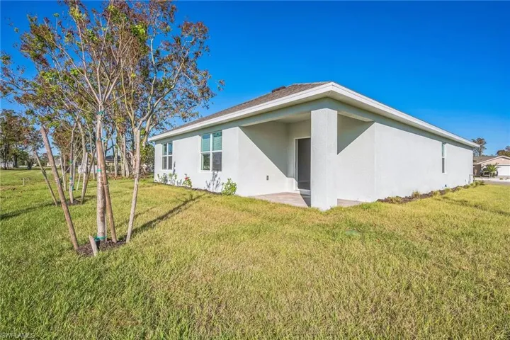 Back of house featuring stucco siding, a patio, and a yard