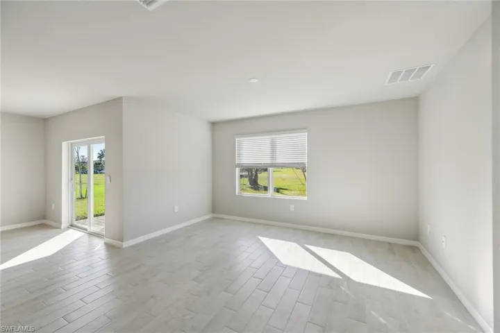 Unfurnished room featuring wood finish floors and plenty of natural light