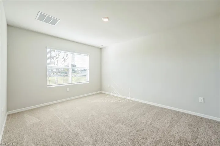 Carpeted spare room featuring baseboards