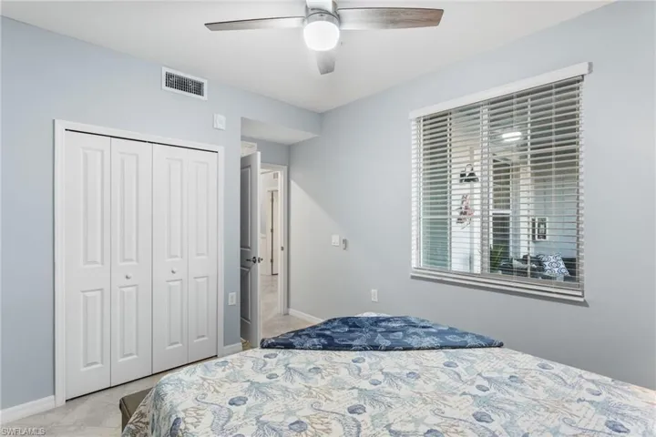 Bedroom with a closet, a ceiling fan, and light colored carpet