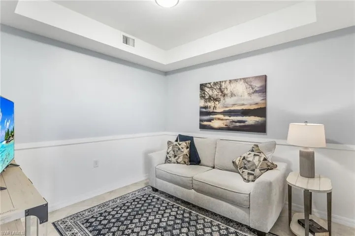 Sitting room featuring a tray ceiling and baseboards