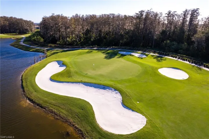 Surrounding community with golf course view, a water view, and view of scattered trees