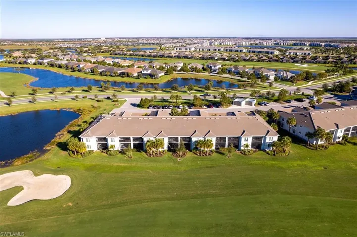 Aerial perspective of suburban area with a golf course and a large body of water