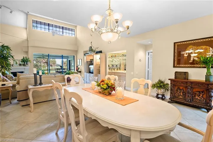 Dining room featuring a chandelier, light tile patterned floors, and a towering ceiling