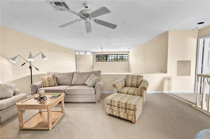 Living area featuring carpet flooring and a ceiling fan