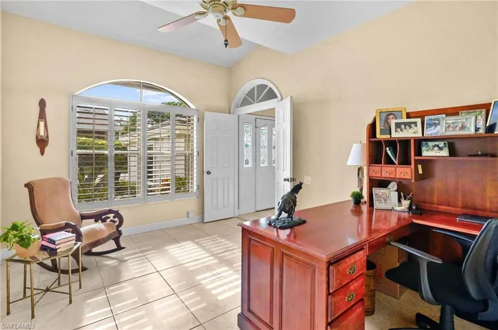 Office area featuring light tile patterned floors, a ceiling fan, and lofted ceiling