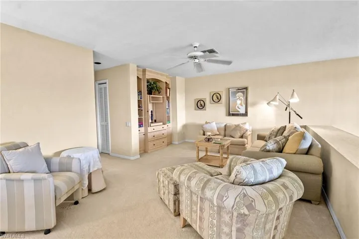 Living area featuring carpet and a ceiling fan