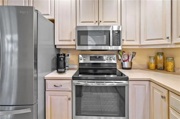 Kitchen featuring stainless steel appliances, light countertops, and light brown cabinetry