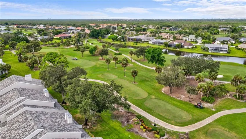 Aerial view of residential area with a local golf course and a nearby body of water