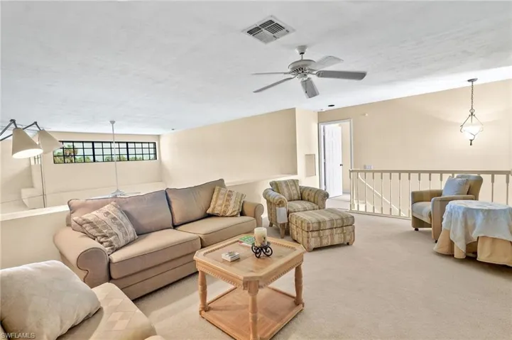 Living area featuring ceiling fan and carpet