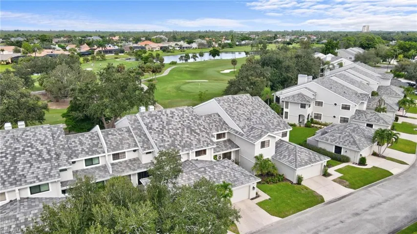 Aerial view of residential area with a golf club and a nearby body of water