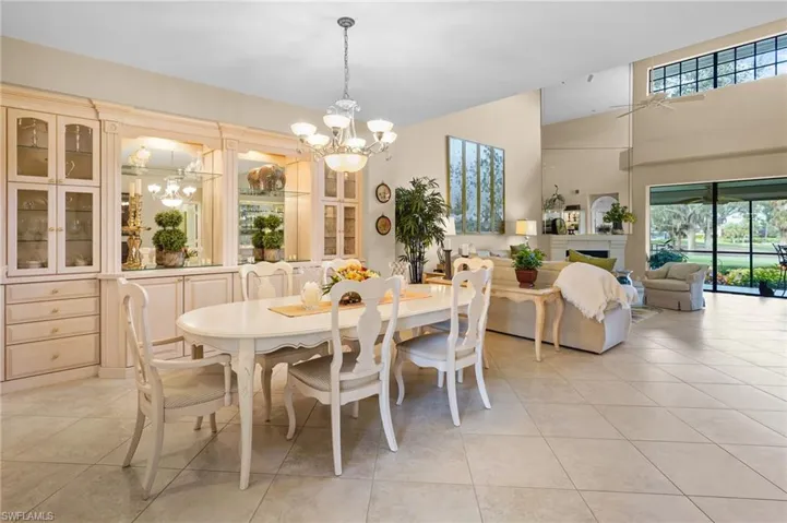 Dining space featuring a chandelier, light tile patterned floors, healthy amount of natural light, and a high ceiling