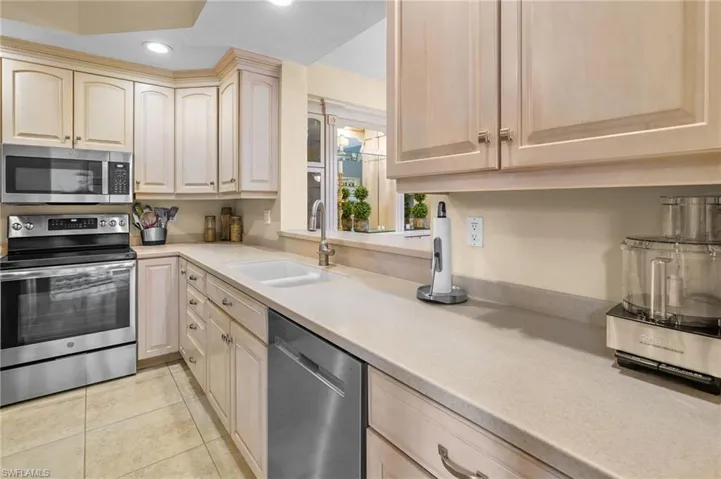 Kitchen with stainless steel appliances, light brown cabinetry, light tile patterned flooring, and recessed lighting